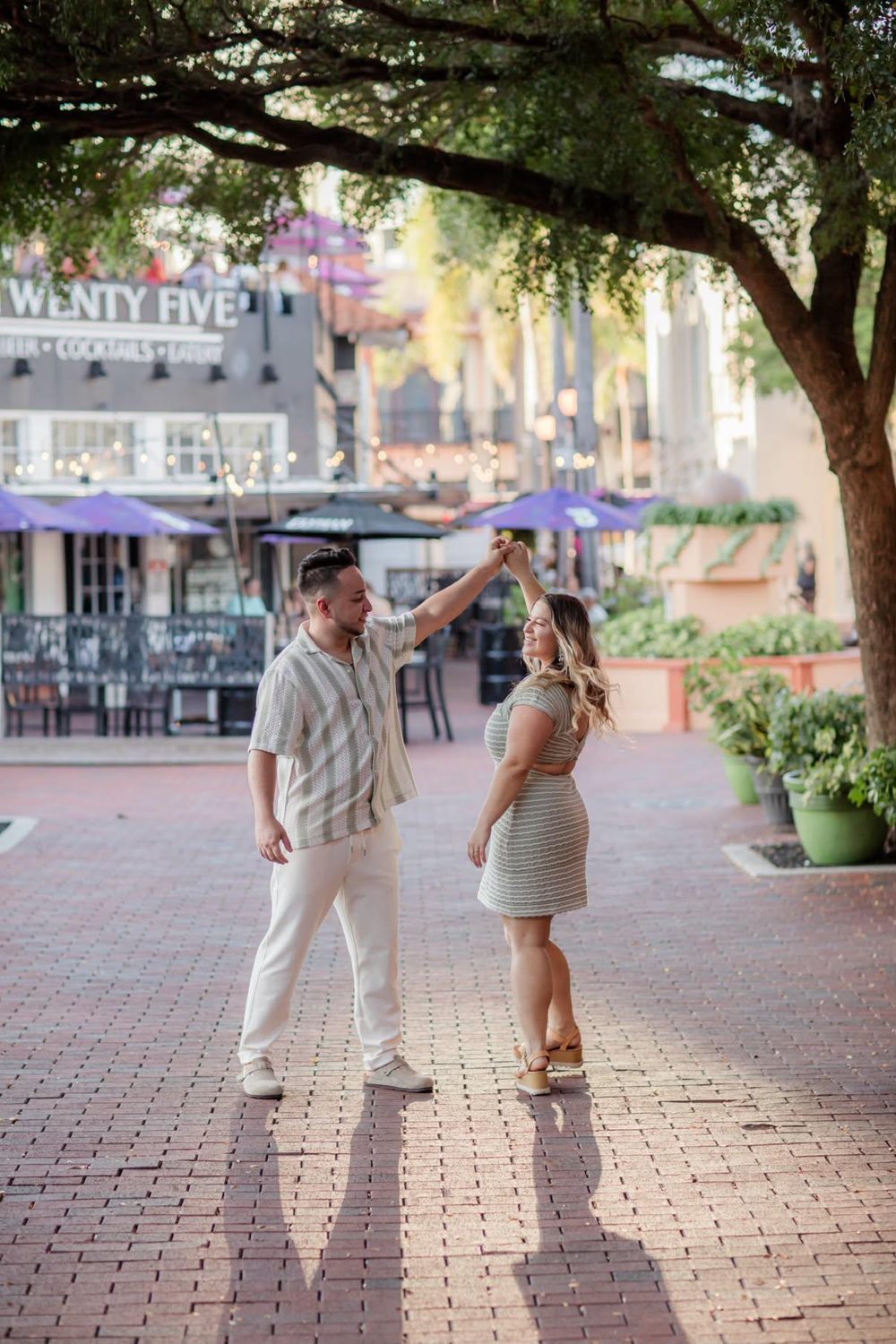 Kallie and Alejandro dancing in a courtyard under the trees