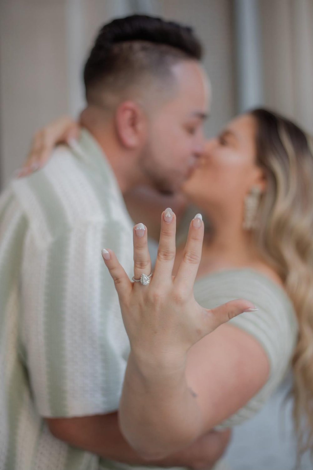 Kallie showing her engagement ring while kissing Alejandro
